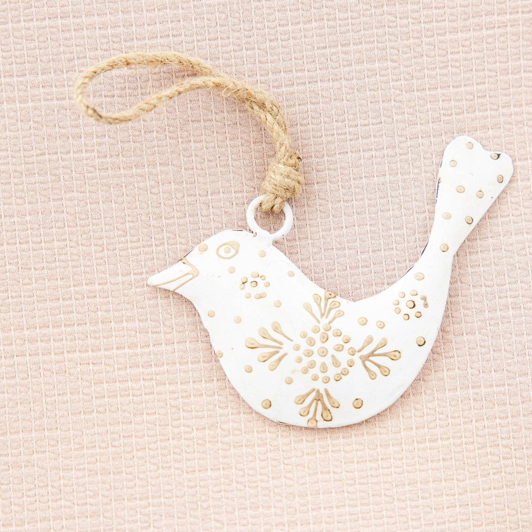 Decorative white bird ornament with gold patterns on a beige background