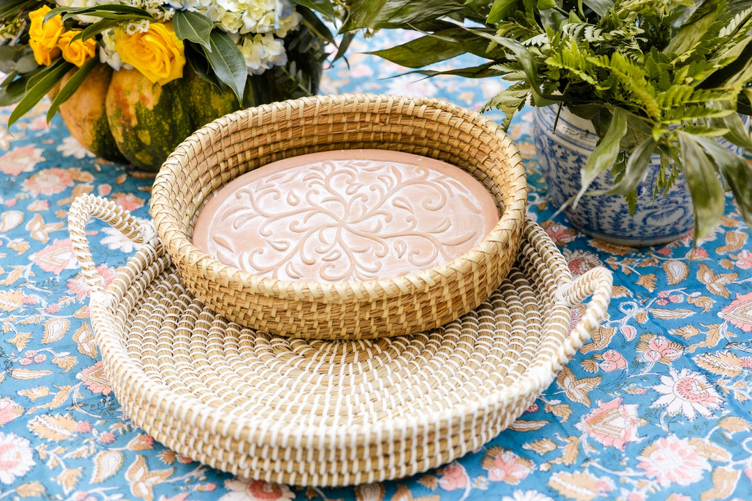 Woven basket with decorative plate on a floral tablecloth
